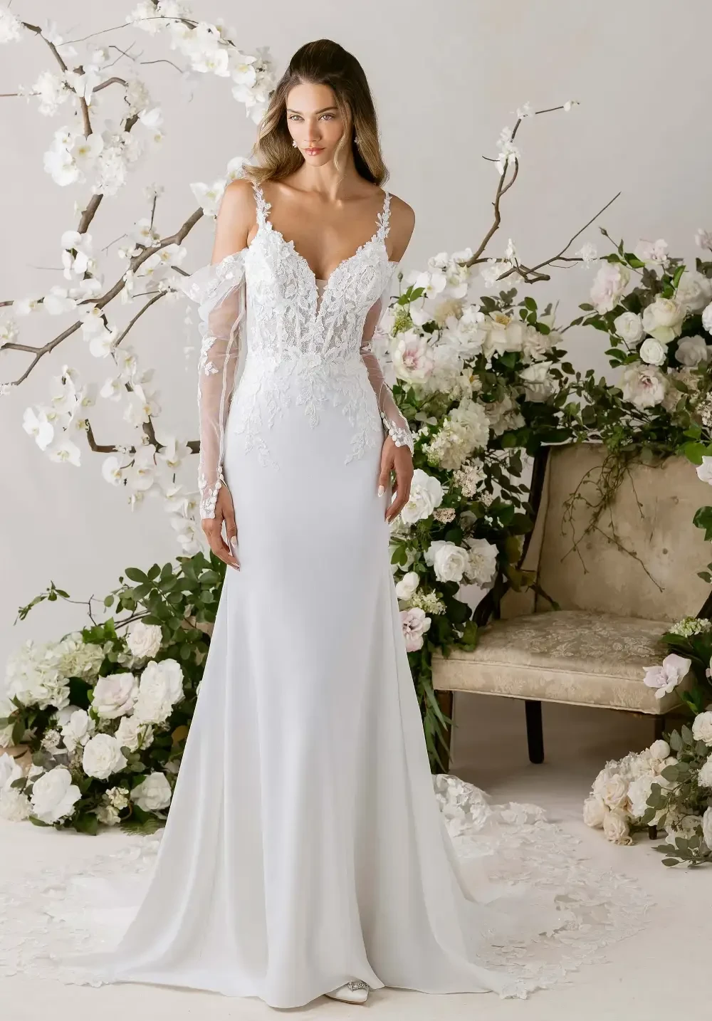 model is wearing an off the shoulder fitted wedding dress