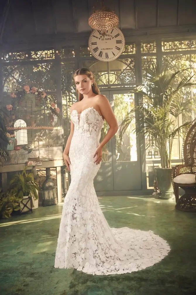 Model is wearing a strapless 3d floral lace wedding dress with a fit and flare silhouette