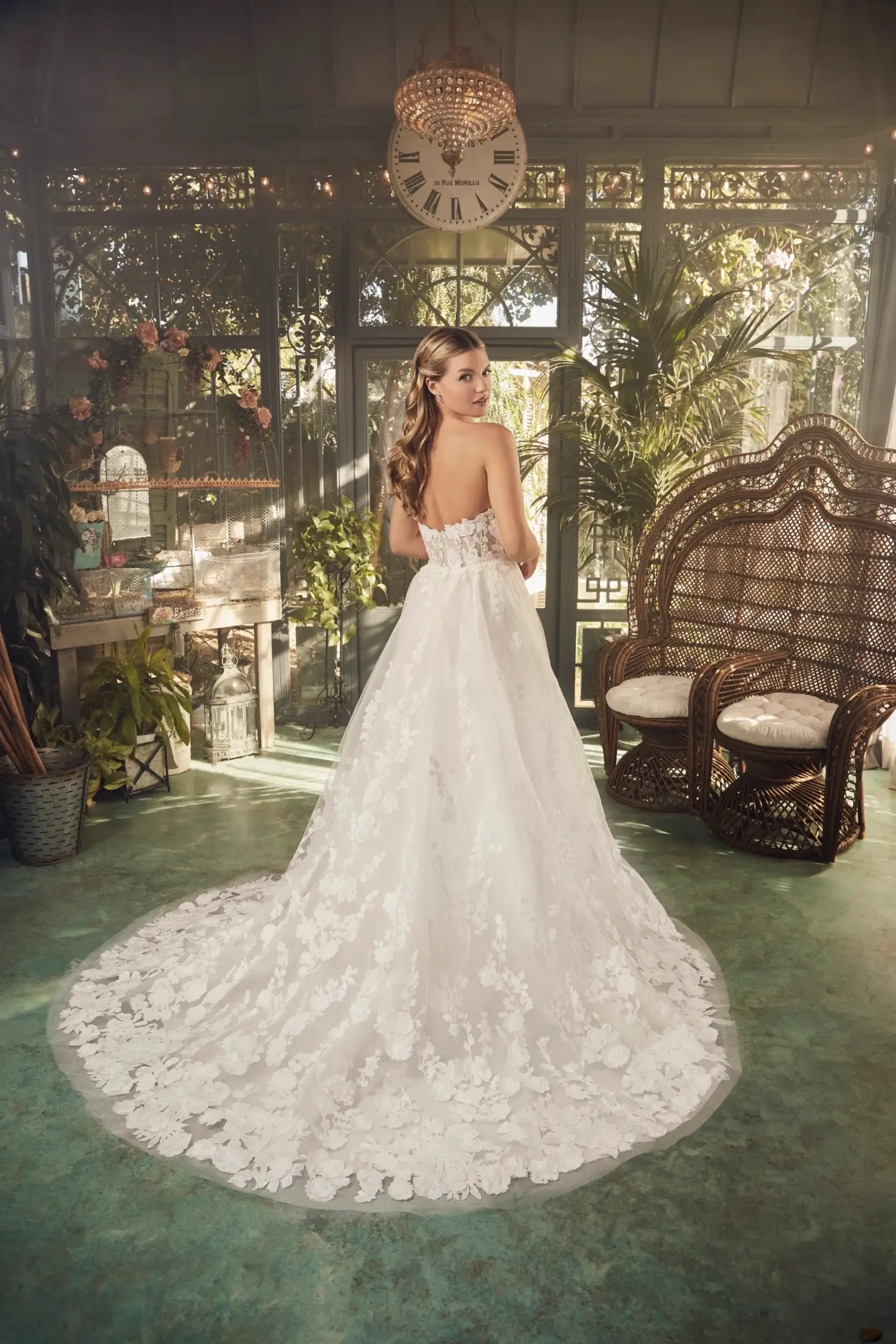 Model is wearing a strapless 3d floral lace wedding dress with a fit and flare silhouette
