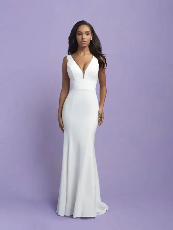 Model is wearing a sleeveless minimalist wedding dress with a plunging neckline and fit and flare silhouette