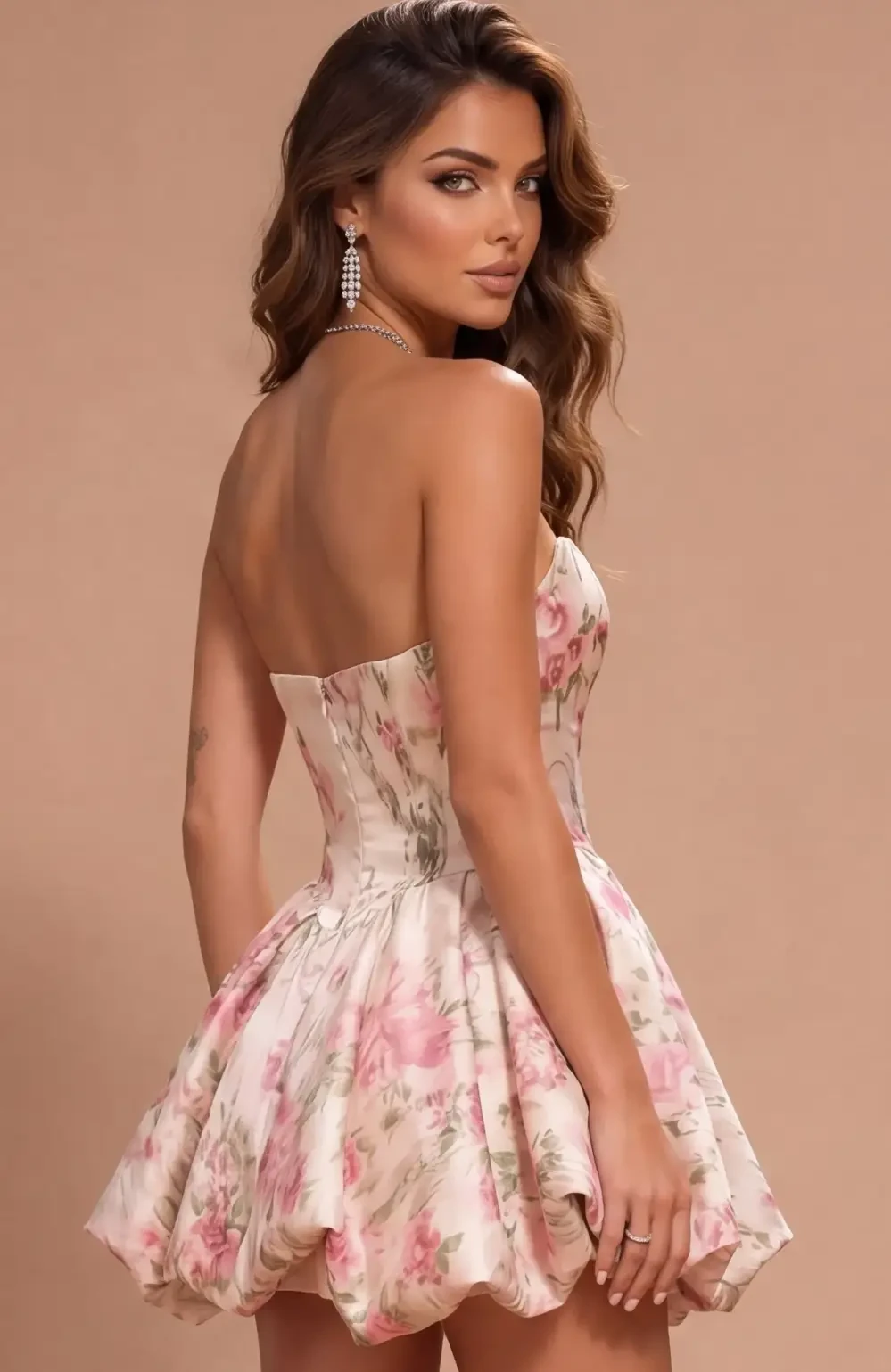 A woman wearing a floral-patterned strapless dress, looking back towards the camera, with wavy hair and earrings.