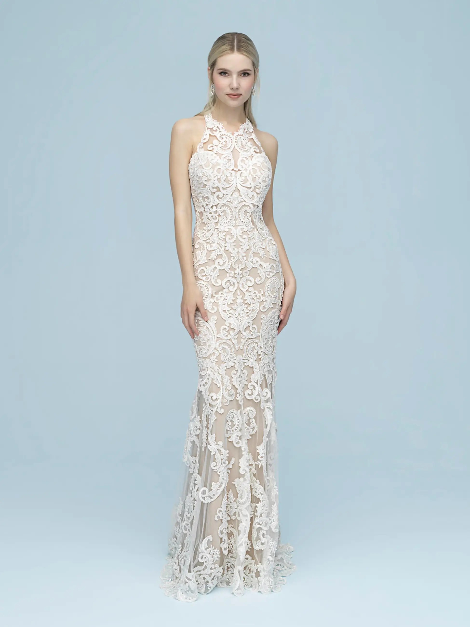 Model is wearing a high neckline sleeveless sheath bridal gown with intricate lace by allure bridals 