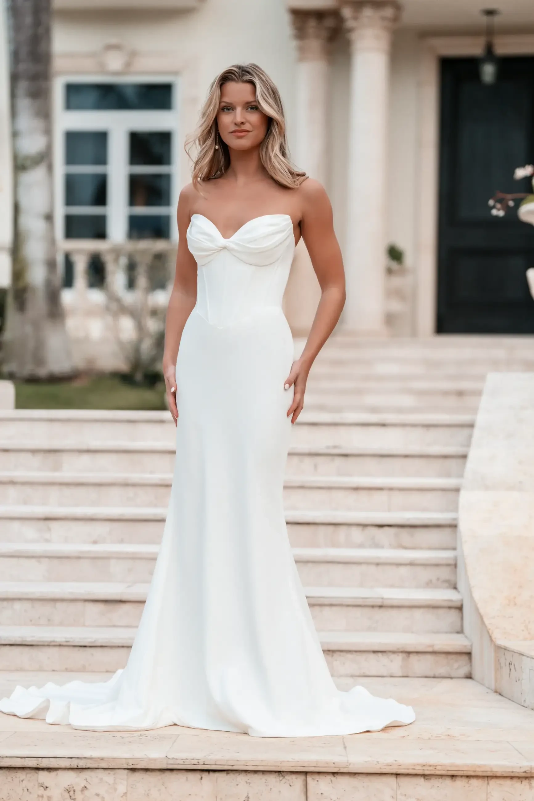 model is wearing a strapless sheath wedding dress