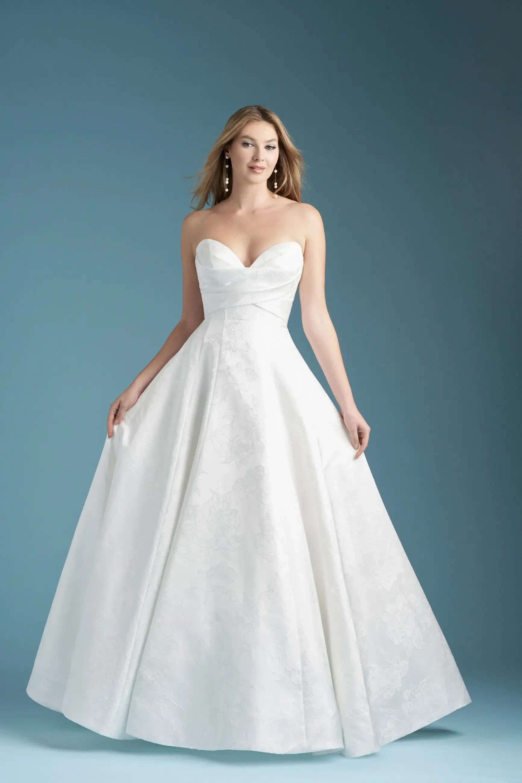 model is wearing a minimalist strapless ball gown wedding dress