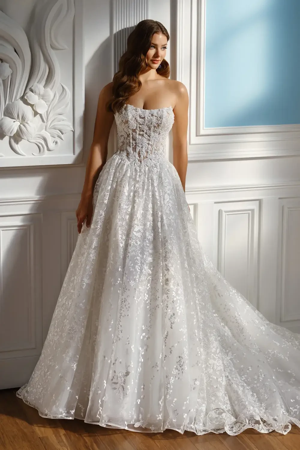 model is wearing a strapless lace ball gown