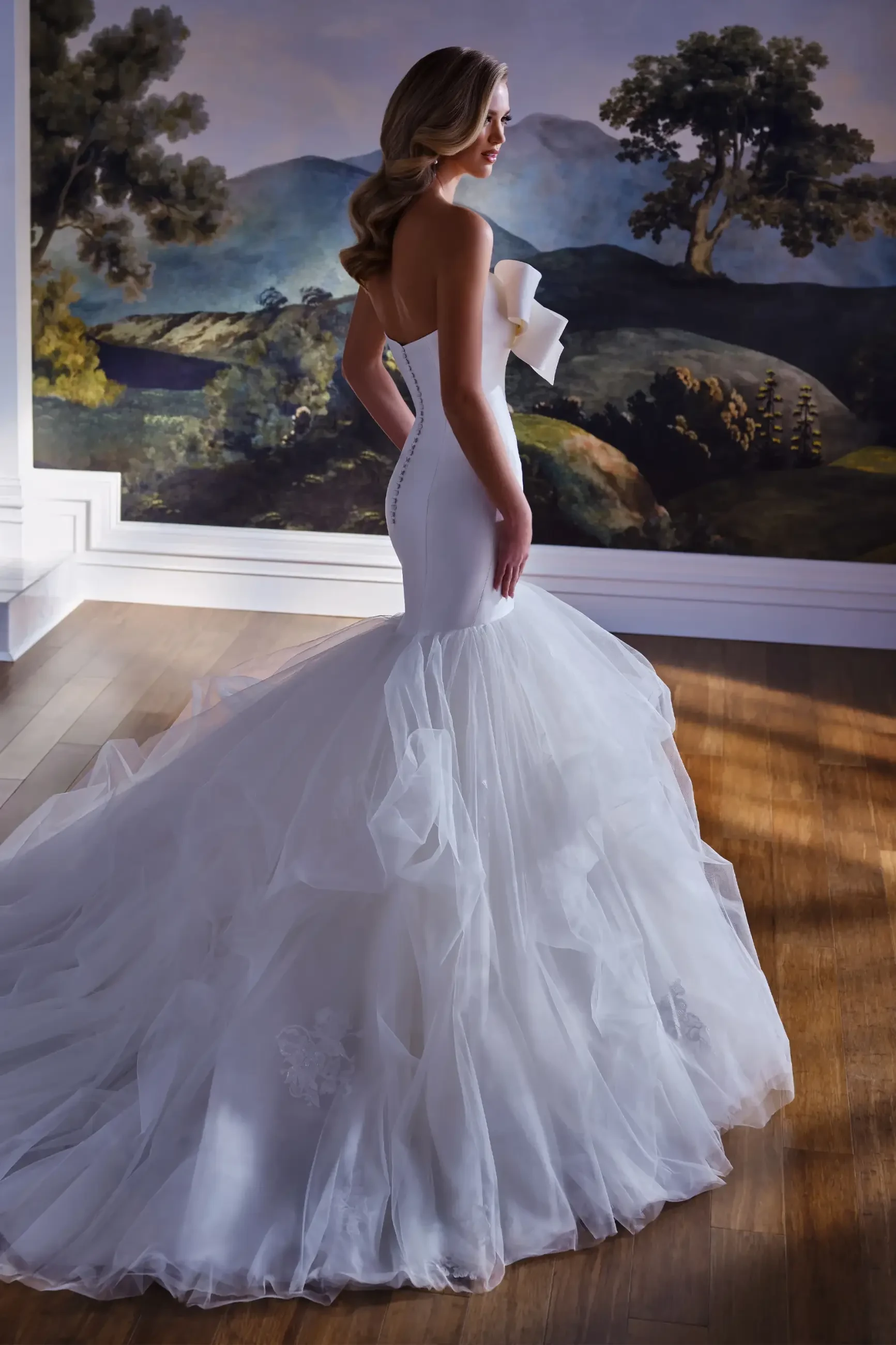 model is wearing a sleek mermaid wedding dress with a full tulle skirt