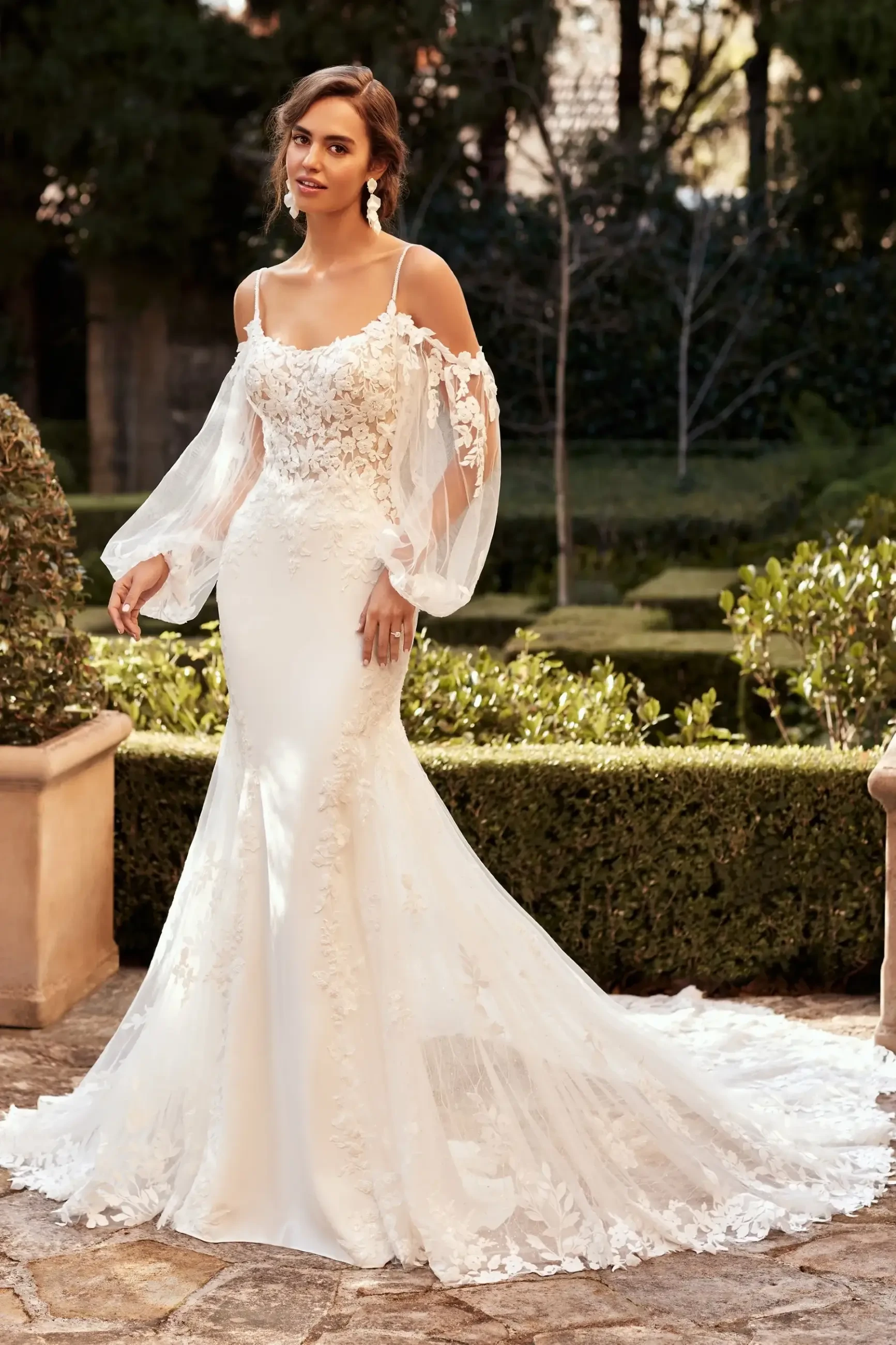 Model is wearing an off the shoulder fit and flare lace wedding dress 